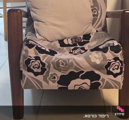 כורסה עם ריפוד פרחוני וכרית אפורה
